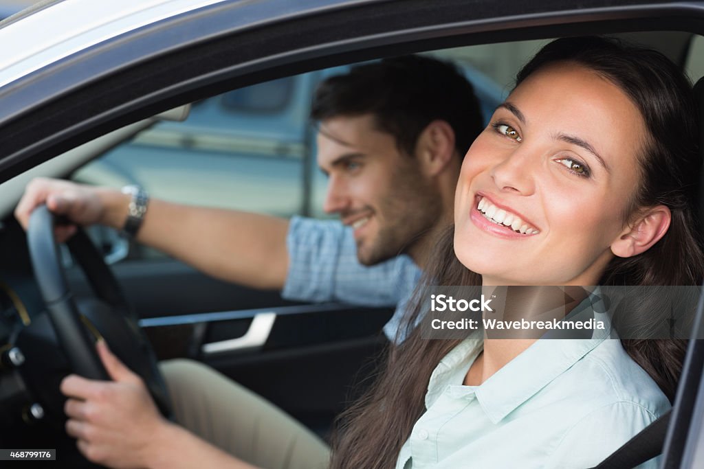 Young couple smiling at the camera Young couple smiling at the camera in their car 20-24 Years Stock Photo