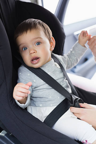 istock Mother securing her baby in the car seat 468799444