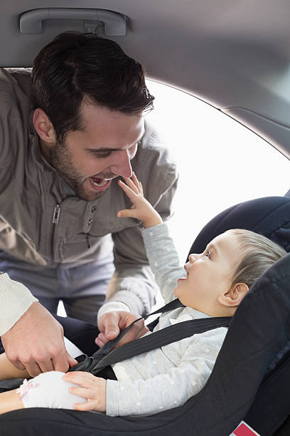 istock Father securing baby in the car seat 468799560