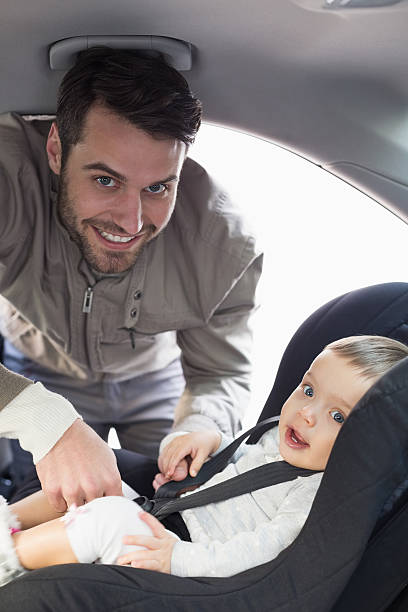istock Father securing baby in the car seat 468799564