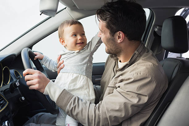 istock Father playing with baby in drivers seat 468799610
