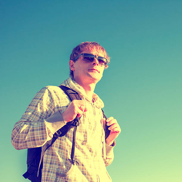 istock Happy man hiker holding backpack and looking at the sunset 468800908