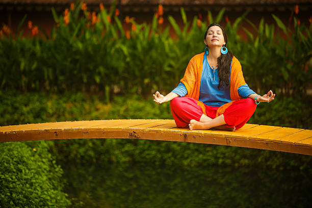 Beautiful woman meditating position at park