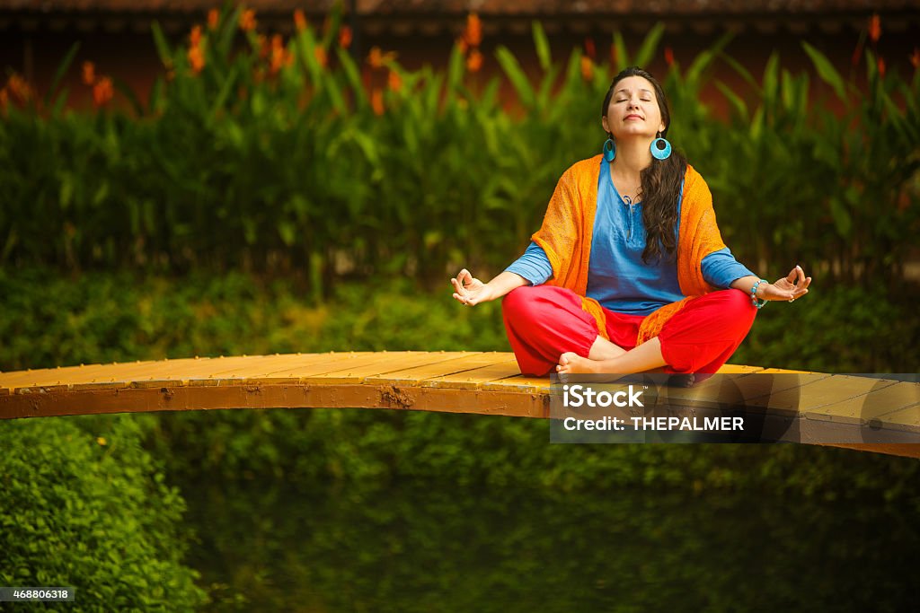 Woman relaxing yoga Yoga in the morning, sitting on a little bridge over a canal. Yoga Stock Photo