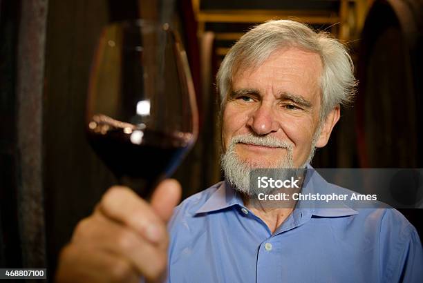 Senior Male Winemaker With Glass Of Red Wine In Cellar Stock Photo - Download Image Now