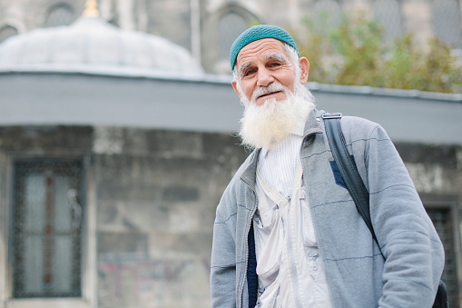 Portrait of old muslim man in his 70s, looking at camera and smiling. Istanbul. Turkey.