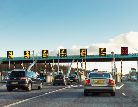 West Midlands, UK - March 4, 2015: Cars queuing to pass through the barriers on the southbound M6 Toll road. The privately funded motorway was opened in 2003.