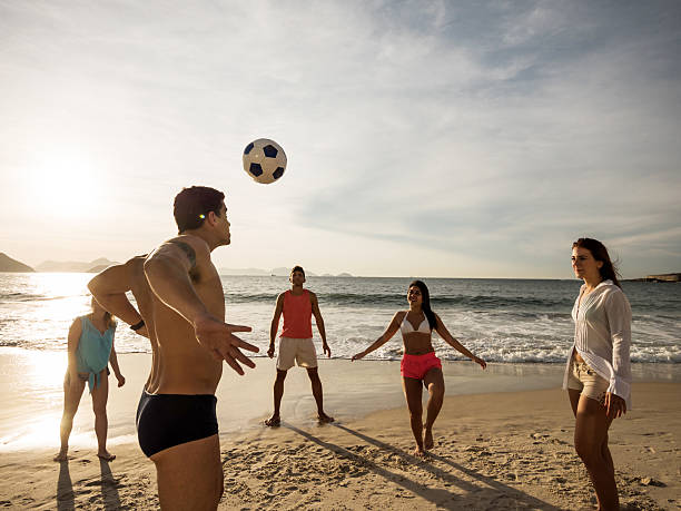 istock Group of friends playing with a ball on the beach. 468808708