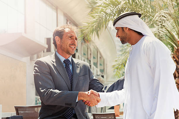 due uomini d'affari che ha colpito un accordo a dubai - middle eastern ethnicity business greeting handshake foto e immagini stock