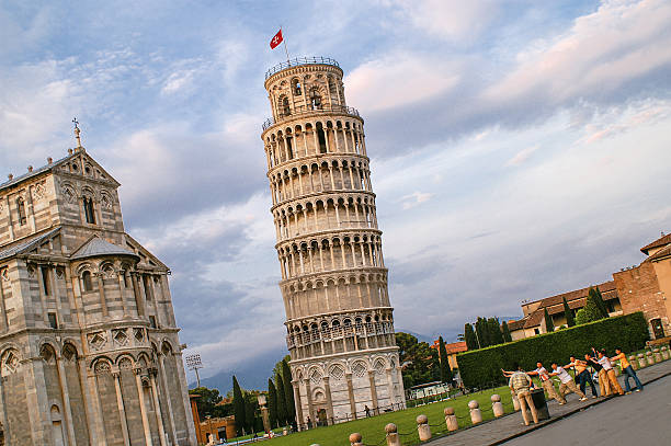 The Leaning Tower of Pisa Pisa, Italy - June 5th, 2006: The Leaning Tower of Pisa, Tuscany, in evening light with a group of Asians taking a group-picture and having fun unesco organised group photos stock pictures, royalty-free photos & images