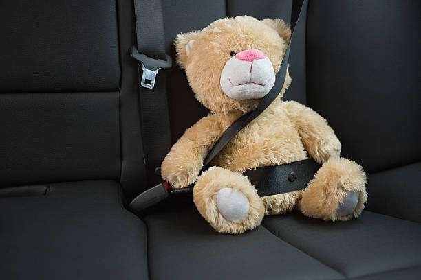 istock Teddy bear strapped in with seat belt 468813588