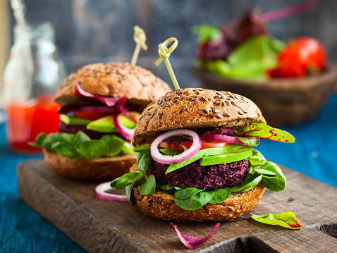 Veggie beet and quinoa burger with avocado on the vintage wooden board