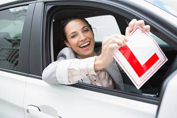 istock Smiling female driver tearing up her L sign 468813710