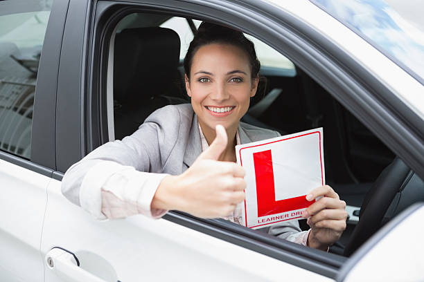 istock Female driver giving thumbs up while holding L sign 468813714