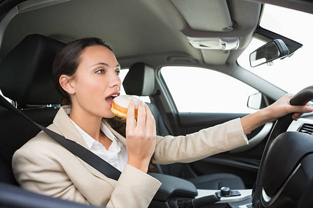 istock Pretty businesswoman having doughnut while driving 468814054