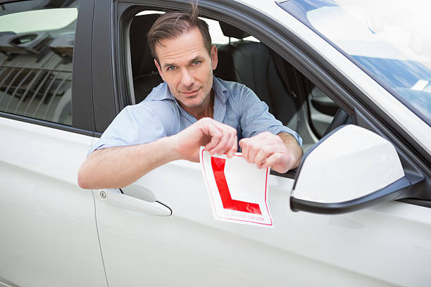 istock Smiling male driver tearing up his L sign 468814092