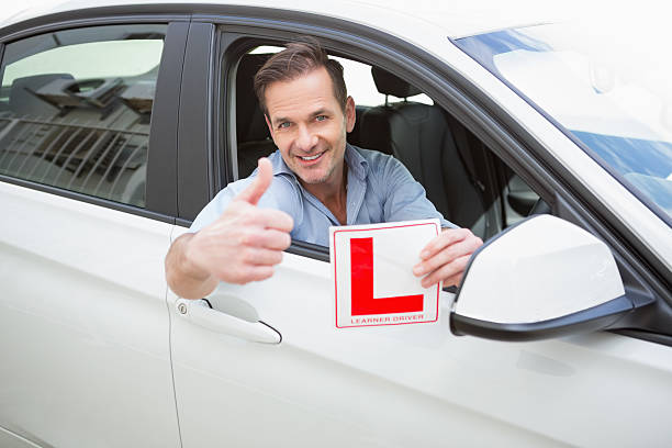 istock Male driver giving thumbs up while holding L sign 468814114