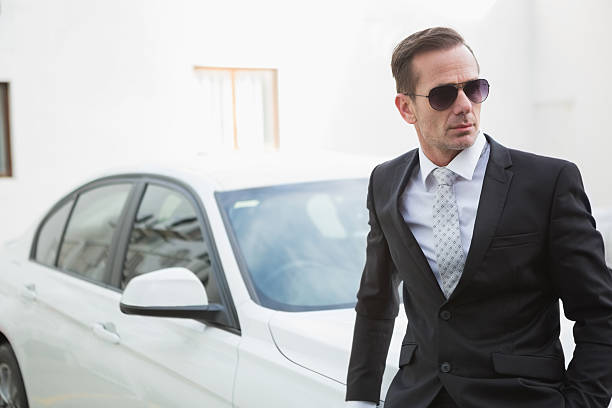istock Serious businessman leaning against his car 468816614