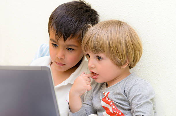 niños con el ordenador portátil - finger in mouth baby baby boys staring fotografías e imágenes de stock