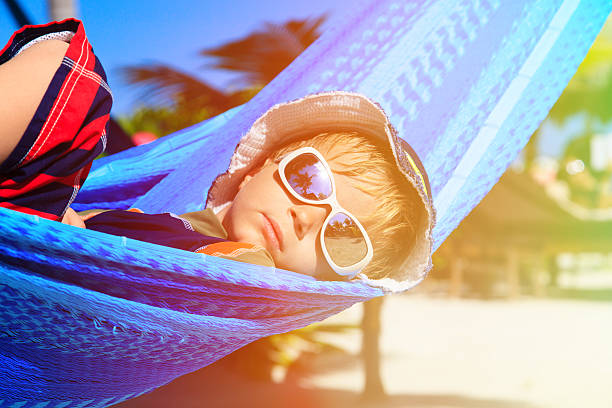 istock happy little boy relaxed in hammock on the beach 468819128