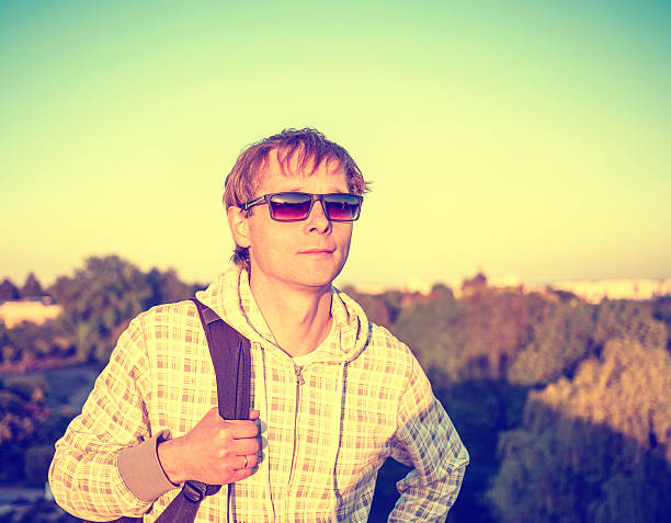 istock Happy man hiker holding backpack and looking at the sunset 468819450