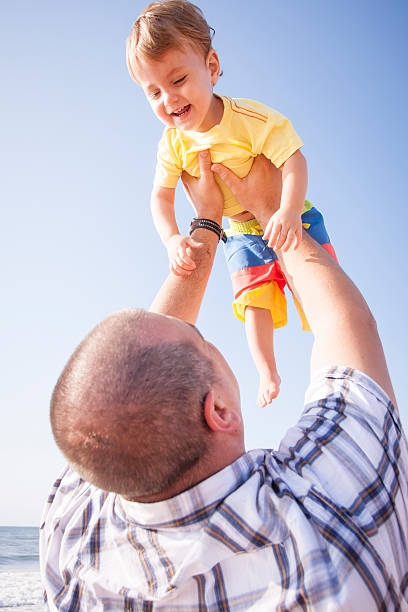 istock Young father holding his son up to the blue sky 468823516
