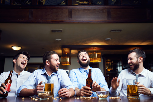 Four businessmen sitting at pub after work