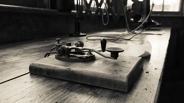 A vintage looking image of a Morse Code & the Telegraph operation clipper use to transmit messages. Antique circa 1920´s. Selective focus. Ideal for themes of communications, obsoleteness and the past.