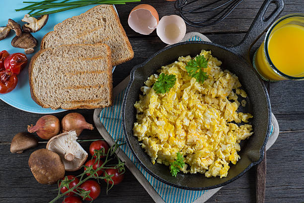 istock scrambled eggs with toast, top view on wooden table 468827550