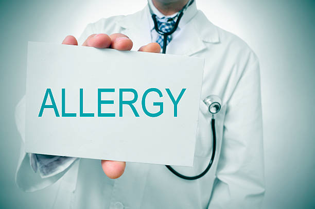 arzt mit einem schild mit dem wort allergie - allergologe stock-fotos und bilder