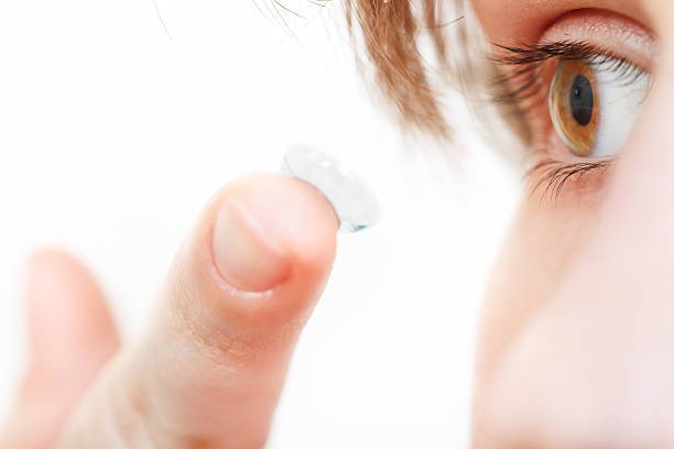 istock girl inserts contact lens in eye 468833416