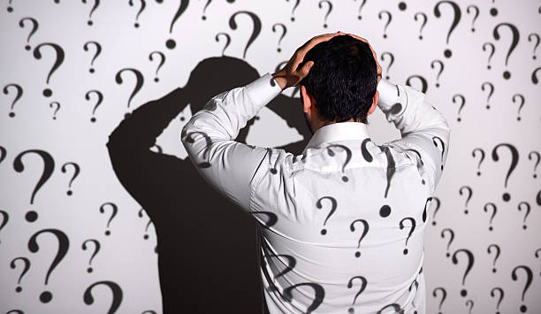 istock Sad businessman standing in front of question marks 468836328