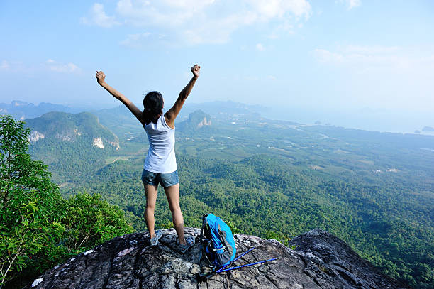 istock cheering hiking woman on mountain peak 468836430