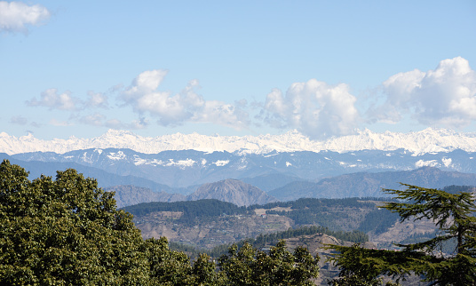 A  view of the Himalayas mountain range looking north-east from the grounds of Viceregal Lodge in Shimla in the Himachal Pradesh state of India. The mountains in the distance remain snow-covered throughout the year and form the border with Tibet.
