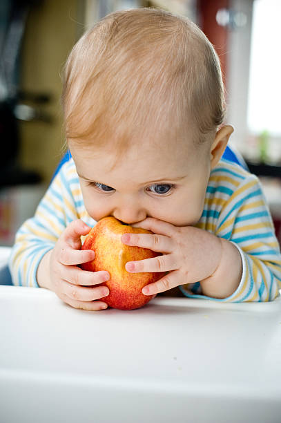 istock Baby with an apple at home;vertical 468836869