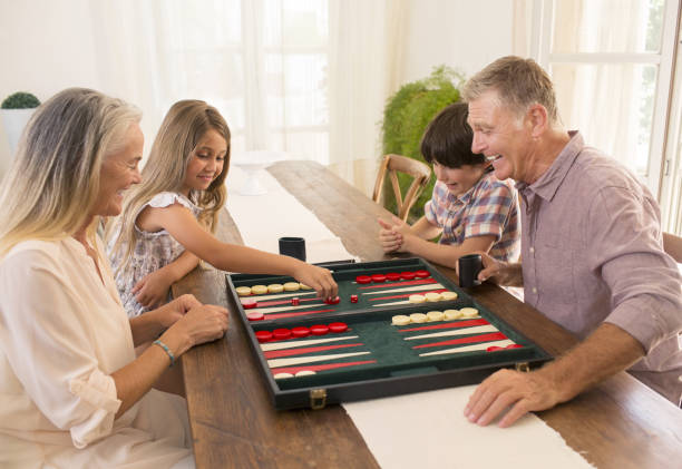 avós e netos a jogar gamão - backgammon imagens e fotografias de stock