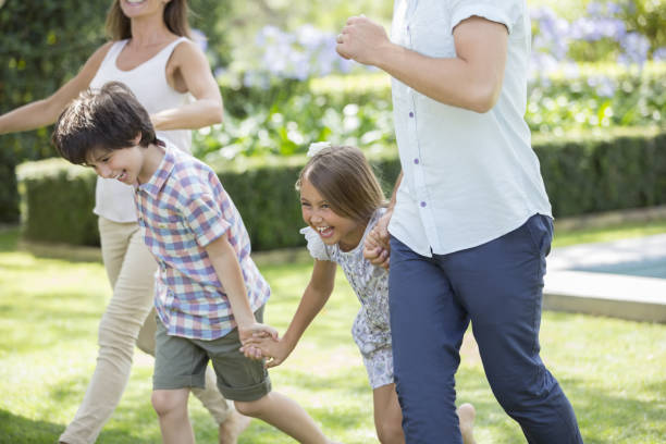 istock Family holding hands and running in backyard 468837735