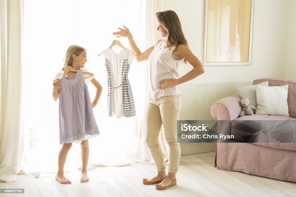 Mother and daughter picking out clothes in bedroom  Child Stock Photo