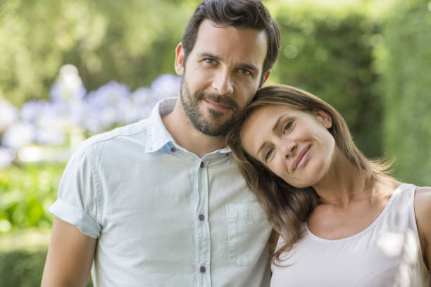 pareja abrazándos'al aire libre - pareja de mediana edad fotografías e imágenes de stock