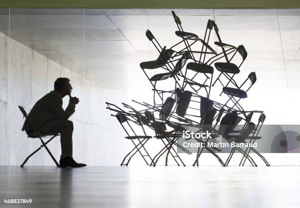 Businessman Viewing Office Chair Installation Art Stock Photo - Download Image Now - Chaos, Complexity, In Silhouette