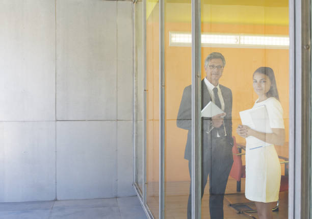 istock Business people smiling at office window 468838019