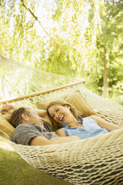 Couple relaxing in hammock outdoors  hammock relaxation women front or back yard stock pictures, royalty-free photos & images