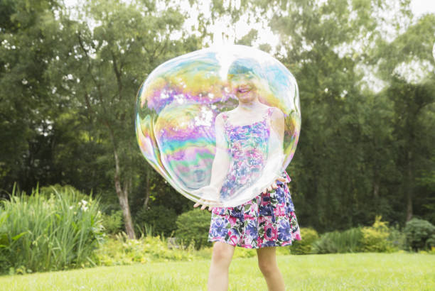 istock Father and daughter playing with large bubbles in backyard 468838277