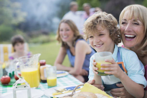 familie gemeinsam im freien essen - family summer portrait nature stock-fotos und bilder