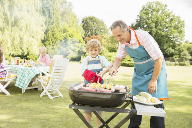 istock Grandfather and grandson grilling meat and corn on barbecue 468838431