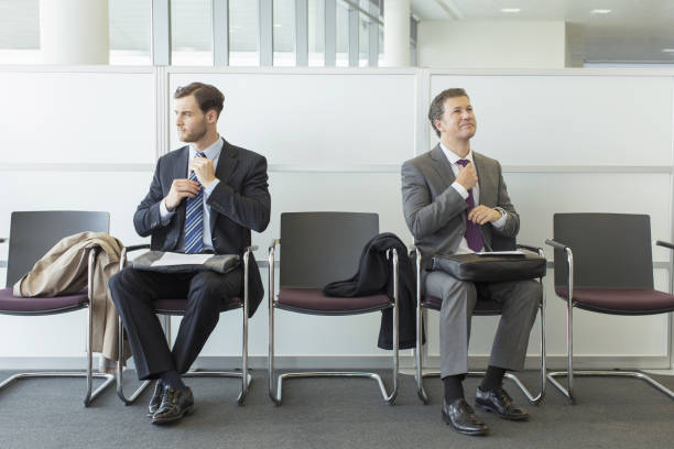 businessmen adjusting ties in waiting area - 13431 뉴스 사진 이미지