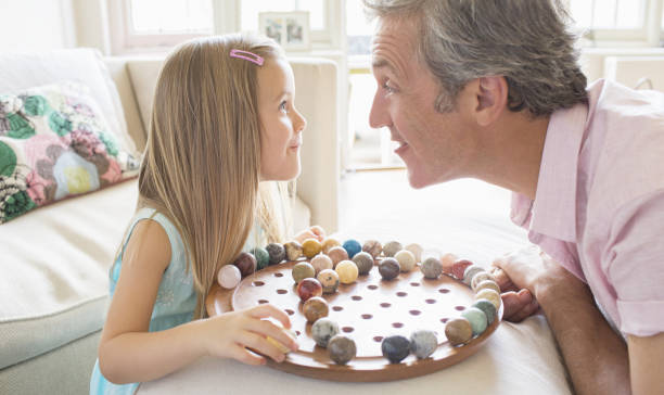 Father and daughter playing Chinese checkers  chinese checkers stock pictures, royalty-free photos & images