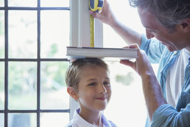istock Father measuring son's height on wall 468839783