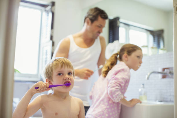 istock Father and children brushing teeth in bathroom 468839821