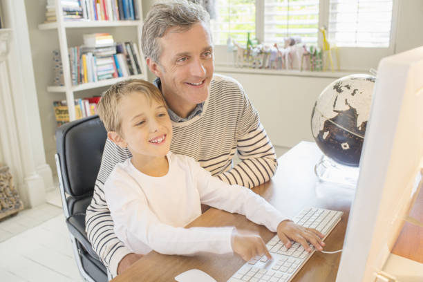 父と息子が一緒にコンピュータを使用 - kid reading ストックフォトと画像